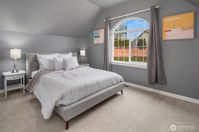 carpeted bedroom with lofted ceiling and baseboards