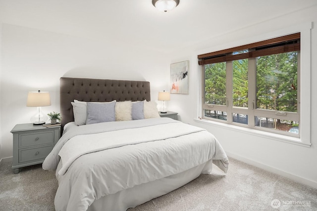 bedroom with baseboards and light colored carpet