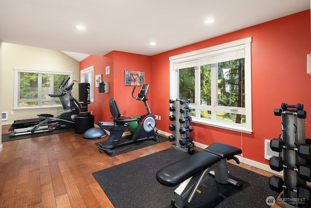 exercise room with baseboards, a wealth of natural light, and wood finished floors