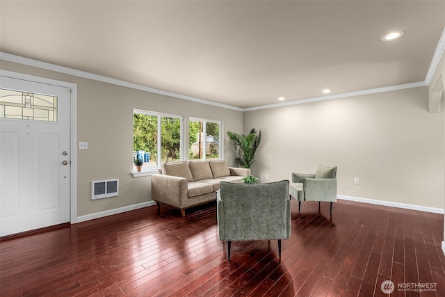 living area with baseboards, wood finished floors, and crown molding