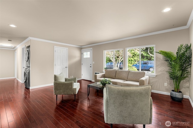 living room with stacked washer and clothes dryer, ornamental molding, baseboards, a healthy amount of sunlight, and dark wood-style flooring