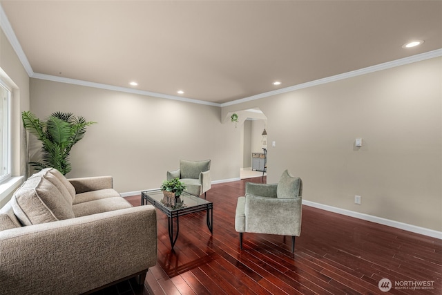 living room featuring crown molding, baseboards, recessed lighting, wood finished floors, and arched walkways