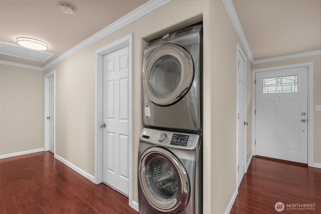 washroom featuring dark wood-style flooring, crown molding, stacked washer / dryer, baseboards, and laundry area