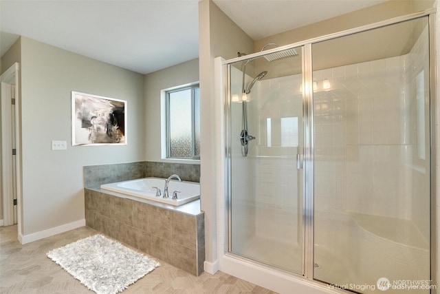 bathroom with a shower stall, a garden tub, and baseboards