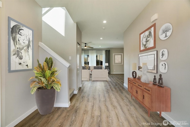 hallway featuring stairs, recessed lighting, wood finished floors, and baseboards