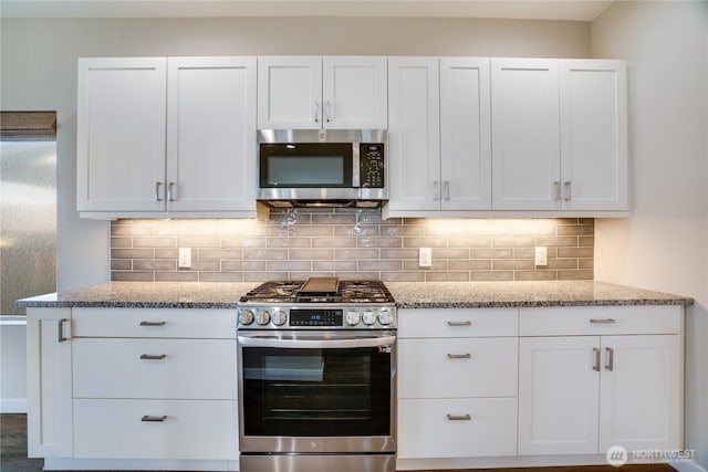 kitchen featuring light stone counters, tasteful backsplash, appliances with stainless steel finishes, and white cabinetry