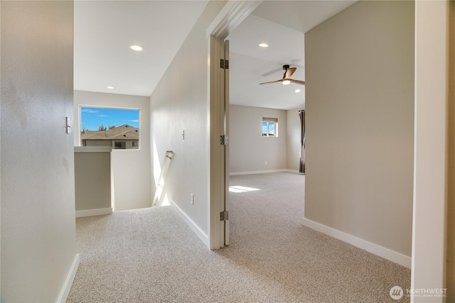 hall with recessed lighting, an upstairs landing, baseboards, and carpet floors