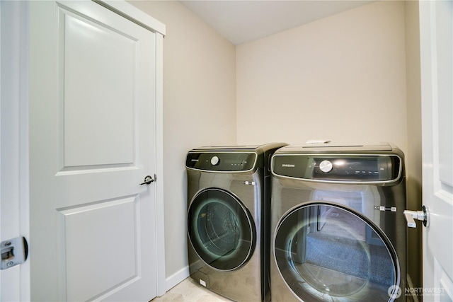 clothes washing area featuring separate washer and dryer and laundry area