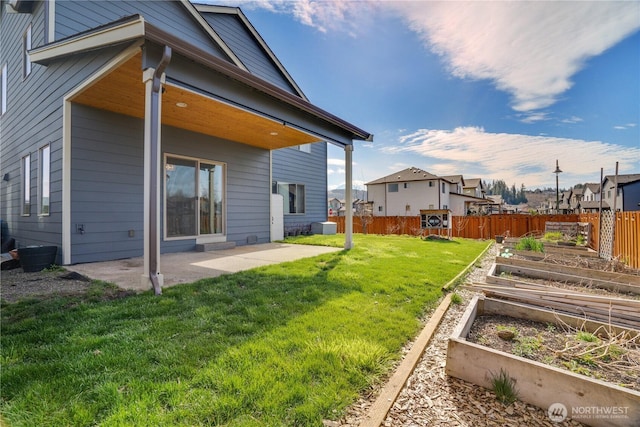 view of yard with a residential view, a patio, a vegetable garden, and fence