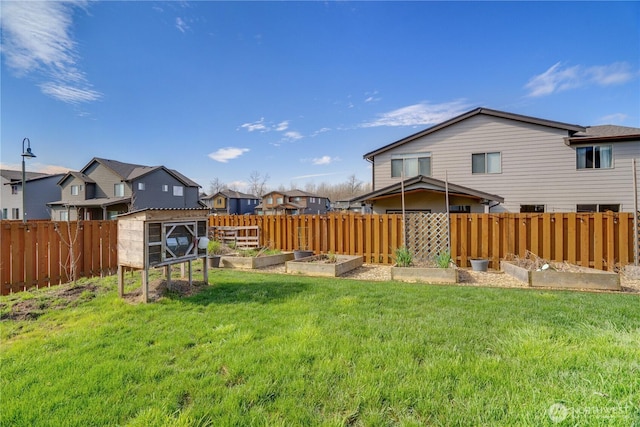 view of yard with a garden, a residential view, and fence