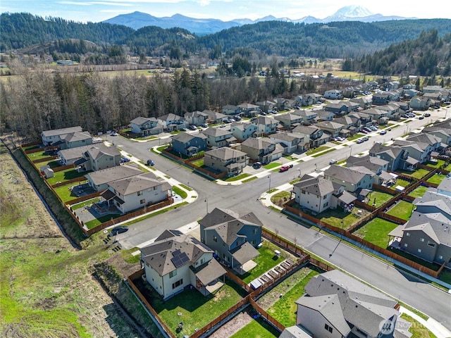 birds eye view of property featuring a mountain view, a residential view, and a wooded view