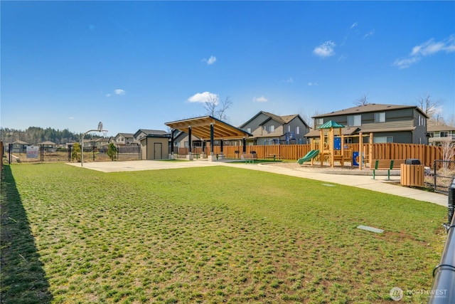 view of yard with a residential view, playground community, and fence