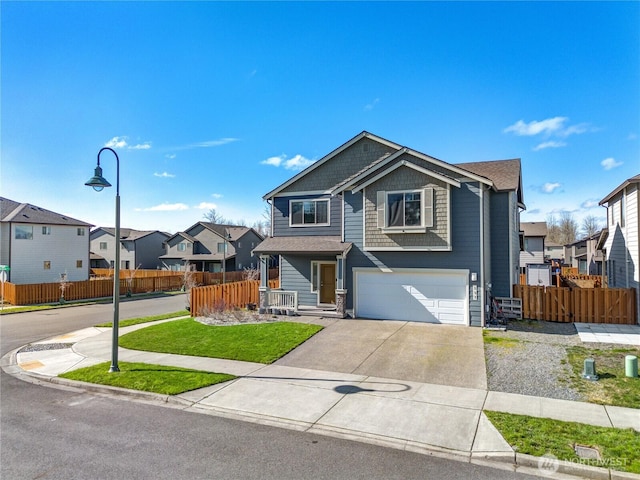 view of front of property featuring an attached garage, fence, a residential view, and driveway