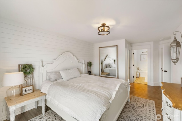 bedroom featuring hardwood / wood-style floors and ensuite bath