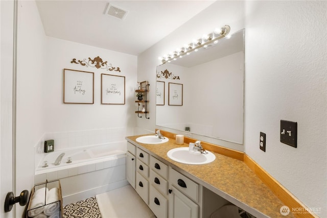 bathroom with vanity and tiled bath