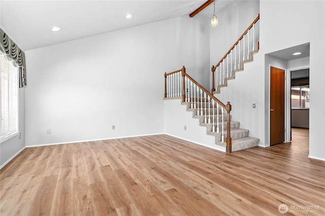 interior space featuring high vaulted ceiling, beam ceiling, and light hardwood / wood-style flooring