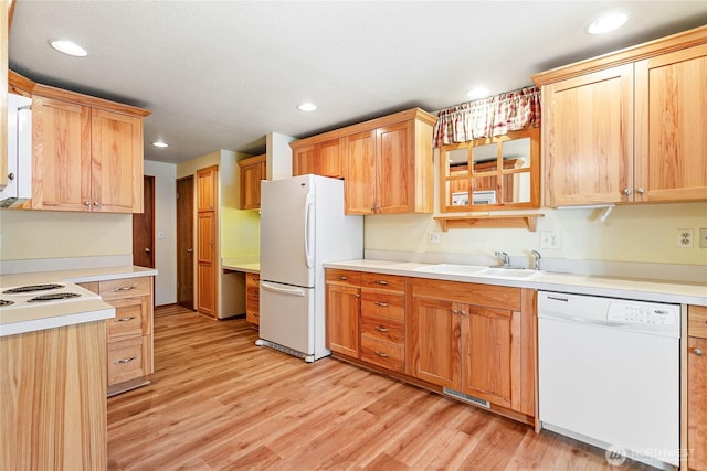 kitchen with sink, white appliances, and light hardwood / wood-style floors