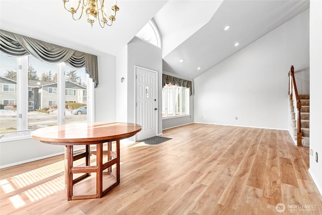 dining space with an inviting chandelier, high vaulted ceiling, and light wood-type flooring