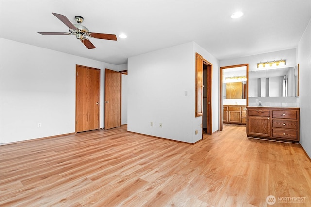 unfurnished bedroom featuring multiple closets, ceiling fan, connected bathroom, and light hardwood / wood-style floors