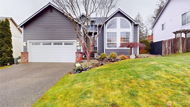 view of front of home featuring fence, brick siding, a front lawn, and driveway