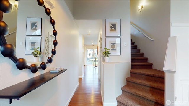 staircase with baseboards and wood finished floors