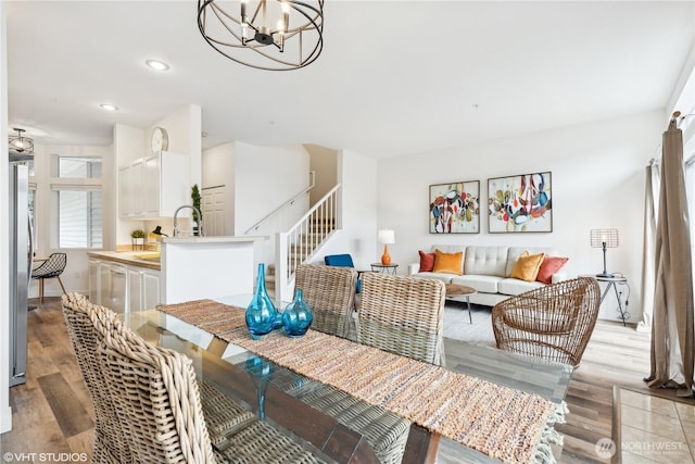 dining area featuring light hardwood / wood-style floors, a chandelier, and sink