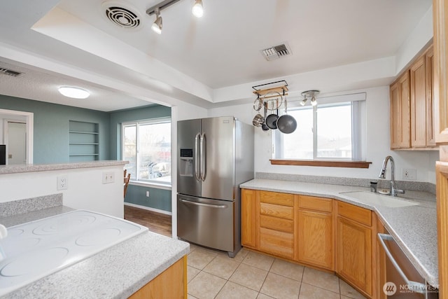 kitchen with stainless steel appliances, rail lighting, sink, and light tile patterned floors