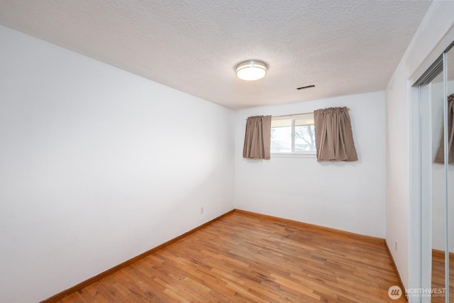 spare room with wood-type flooring and a textured ceiling