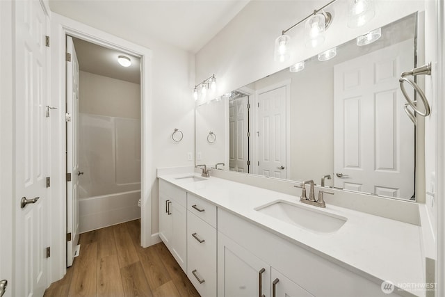 bathroom featuring wood-type flooring, bathing tub / shower combination, and vanity