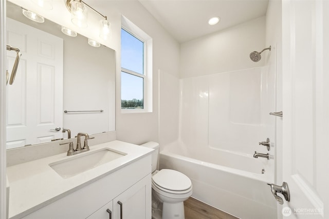 full bathroom featuring vanity, hardwood / wood-style flooring,  shower combination, and toilet