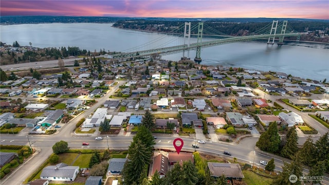 aerial view at dusk featuring a water view