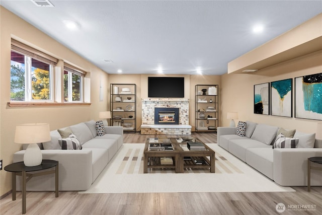 living room with a fireplace and light wood-style flooring