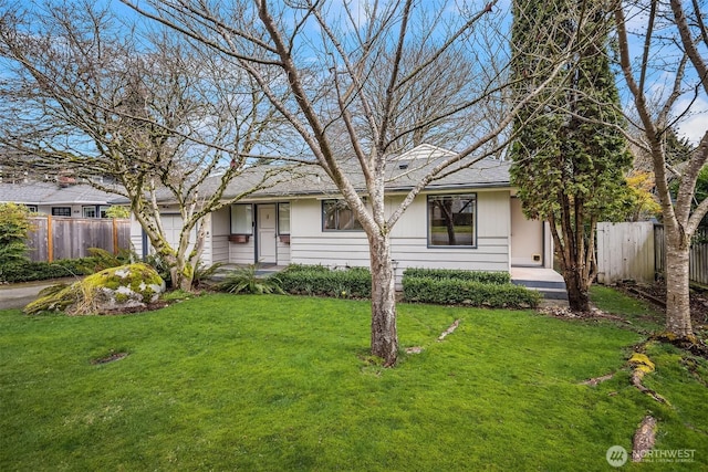 view of front of property featuring a garage, a front yard, and fence