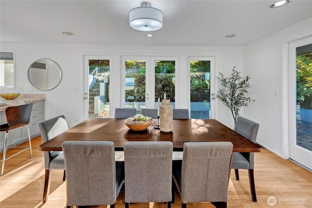 dining room with french doors and light hardwood / wood-style flooring