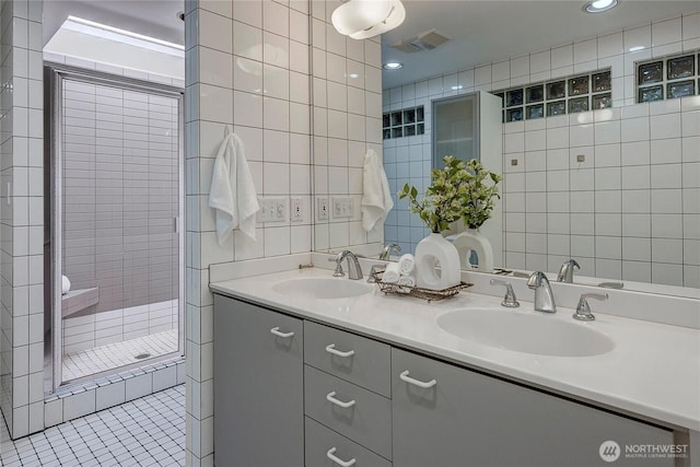 bathroom featuring vanity, tiled shower, and tile walls