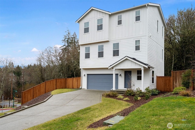 view of front of property with a garage, fence, driveway, a front lawn, and board and batten siding