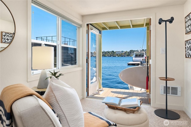 interior space featuring carpet floors, a water view, visible vents, and baseboards