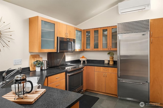 kitchen featuring a wall unit AC, lofted ceiling, glass insert cabinets, stainless steel appliances, and a sink