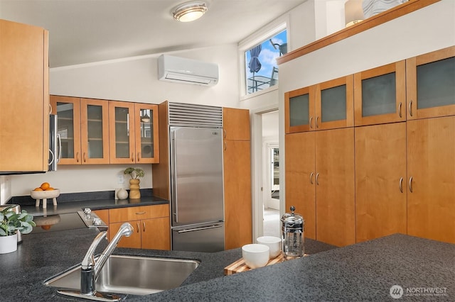 kitchen with a wall unit AC, stainless steel appliances, brown cabinetry, glass insert cabinets, and a sink