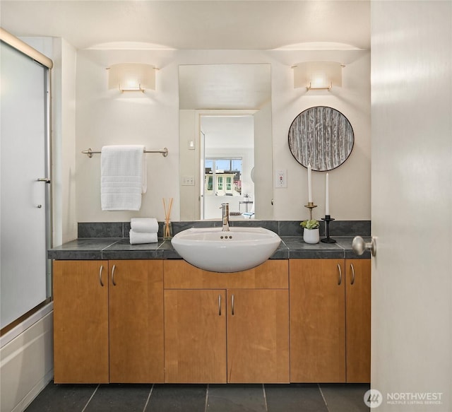 bathroom featuring tile patterned flooring, a shower with door, and vanity