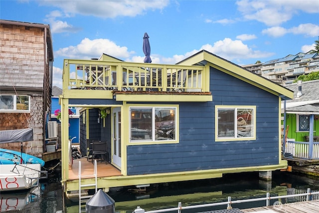 rear view of house featuring a water view and a balcony
