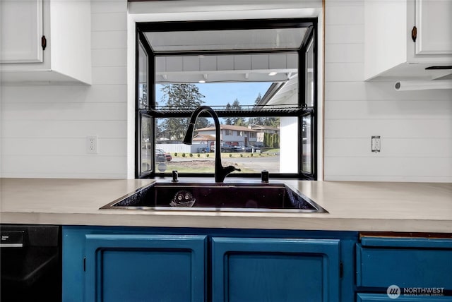 kitchen featuring blue cabinetry, white cabinetry, black dishwasher, and a sink