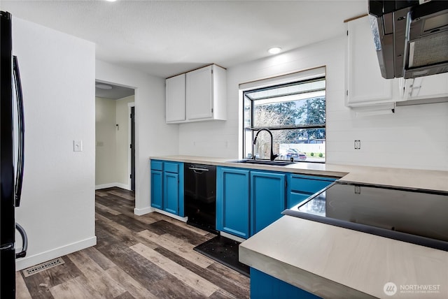 kitchen with dark wood finished floors, a sink, black appliances, white cabinets, and blue cabinets