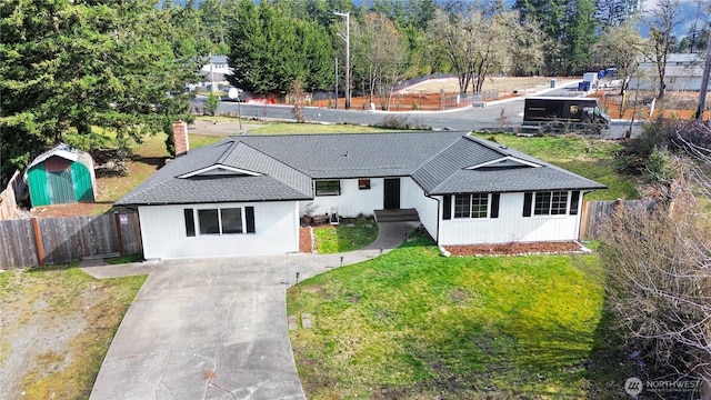 ranch-style house with a chimney, roof with shingles, a front yard, and fence