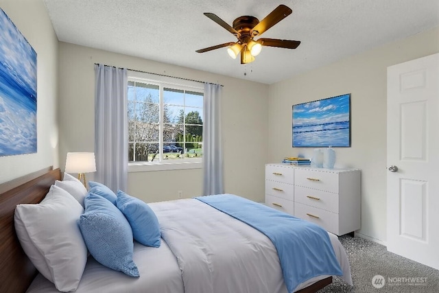 bedroom with ceiling fan, carpet flooring, and a textured ceiling