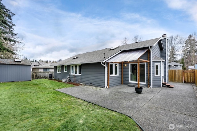 rear view of property featuring a shed, a patio, and a lawn