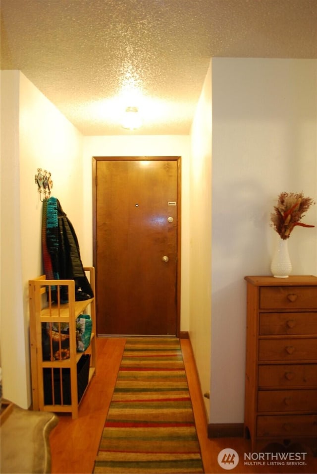 hallway with dark wood-style floors and a textured ceiling