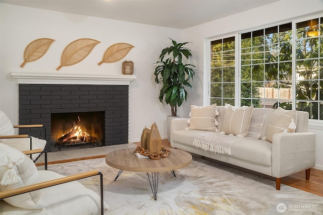 living area featuring a brick fireplace and light hardwood / wood-style flooring