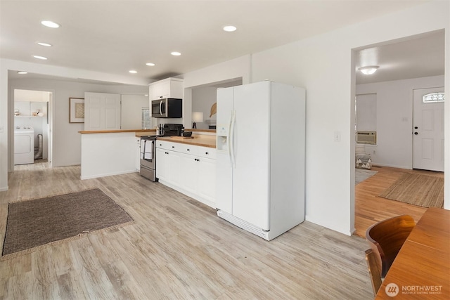 kitchen featuring wood counters, white cabinetry, light hardwood / wood-style flooring, appliances with stainless steel finishes, and washer / clothes dryer