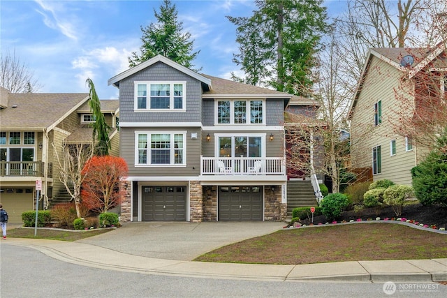 view of front of property with stone siding, driveway, an attached garage, and stairs